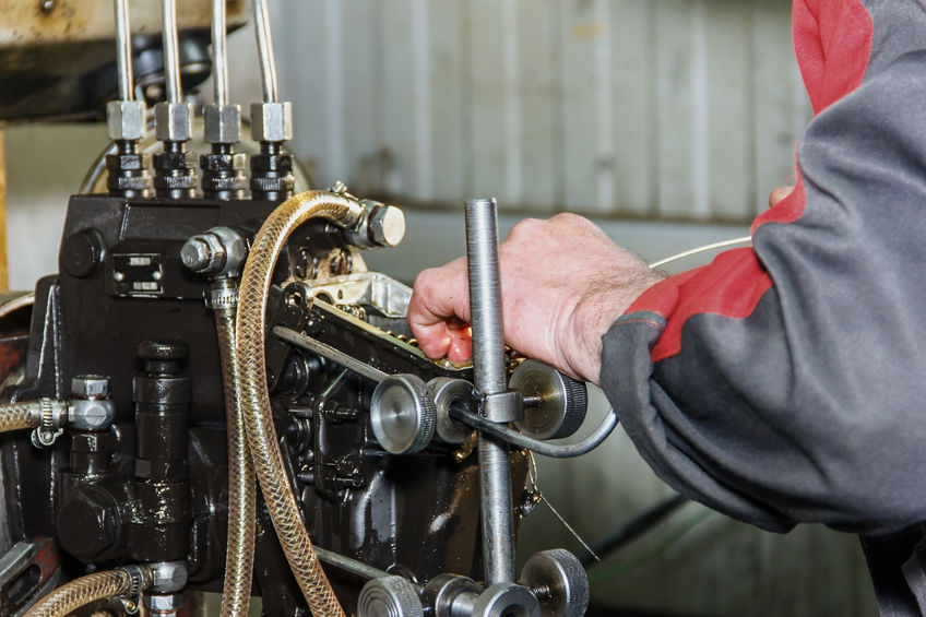 Professional mechanics testing diesel injector in his workshop,