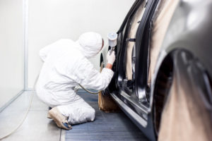 student attending auto collision repair school painting vehicle